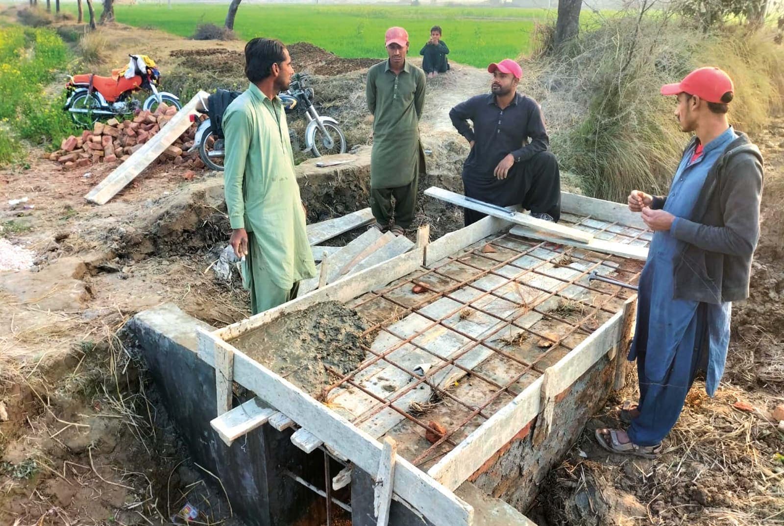Village men building a covered sanitation channel in rural Sindh