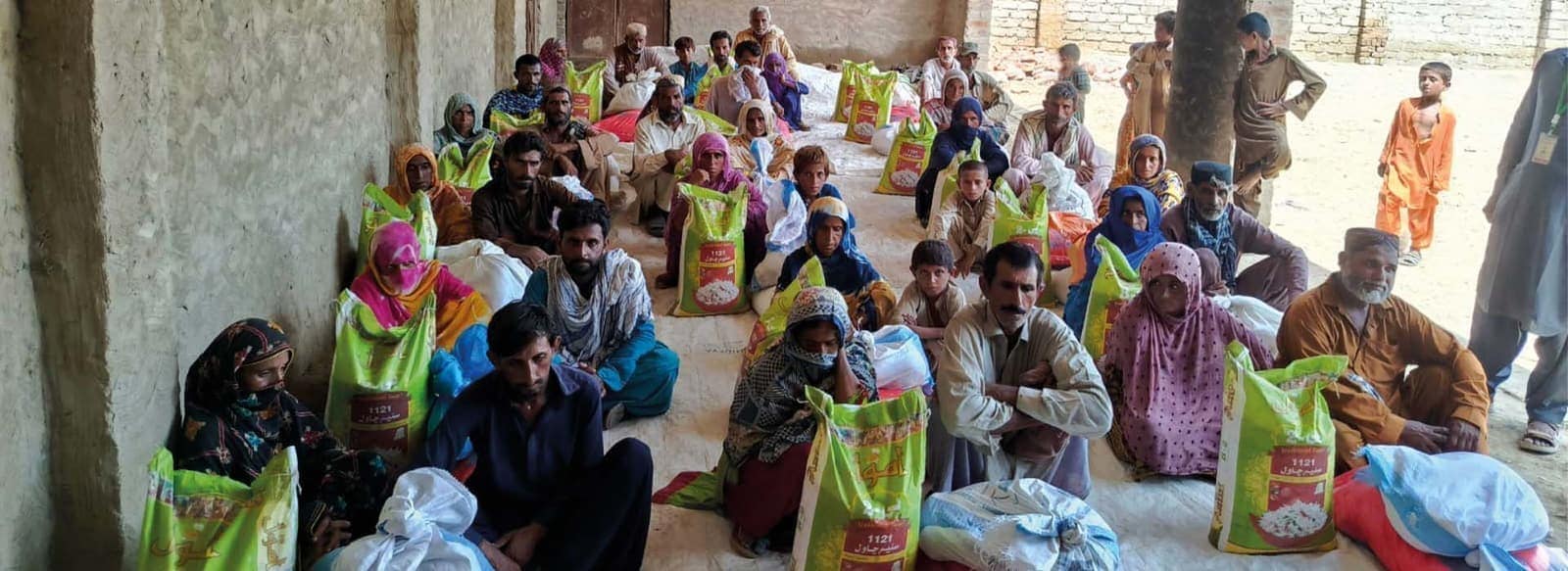 Families receiving emergency food rations at a Trust distribution in rural Sindh